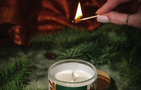 Cinnamon & Star Anise candle sitting in middle fir branches about o be lite with candle.